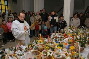 Priest blessing food and flowers during the Polish Festival of Greenery.